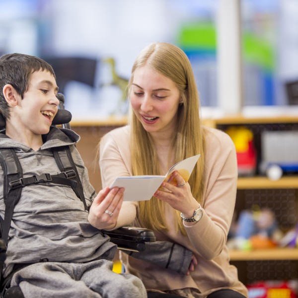 Lady reading to disabled boy